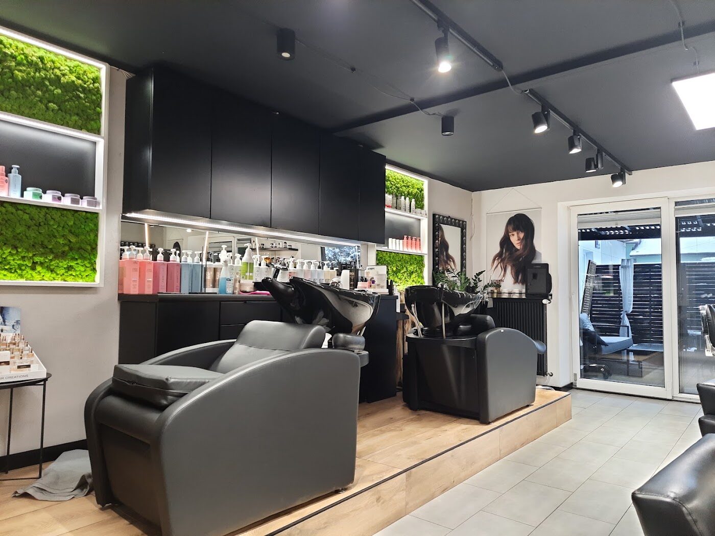 Wnętrze salonu Hair & Beauty Concept z zielonym mchem na ścianie i drewnianymi listwami